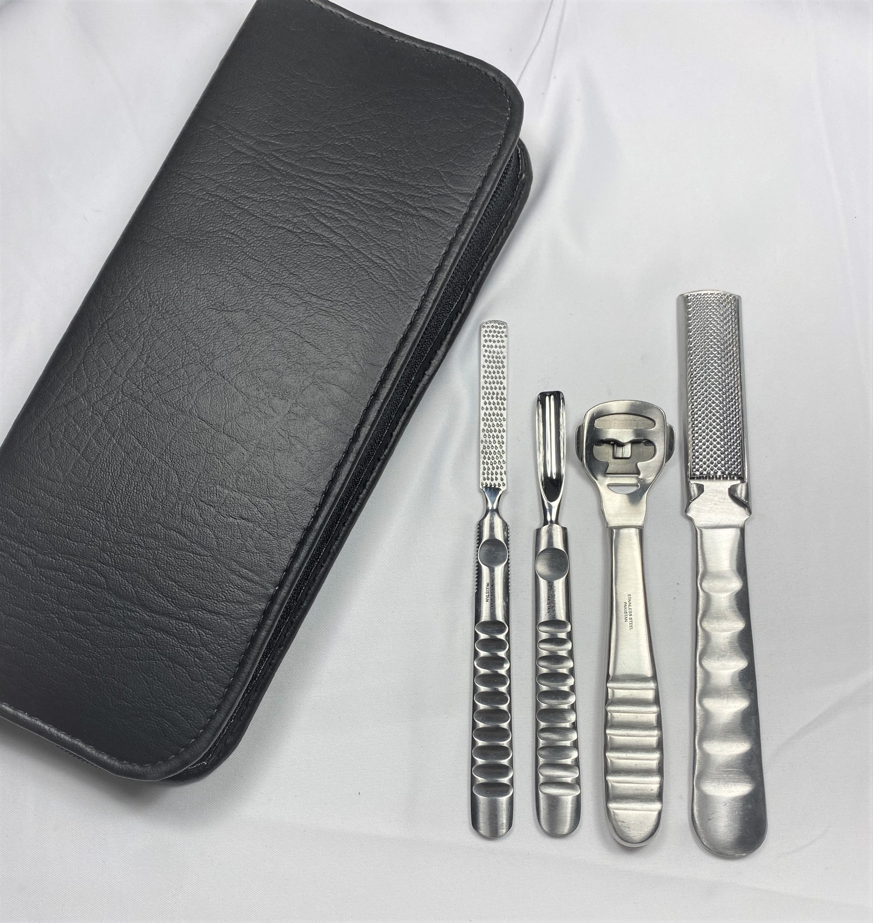 A professional-grade Stainless Steel Foot Care Set featuring four essential tools in a deluxe zipper case, showcasing their elegant satin finish.