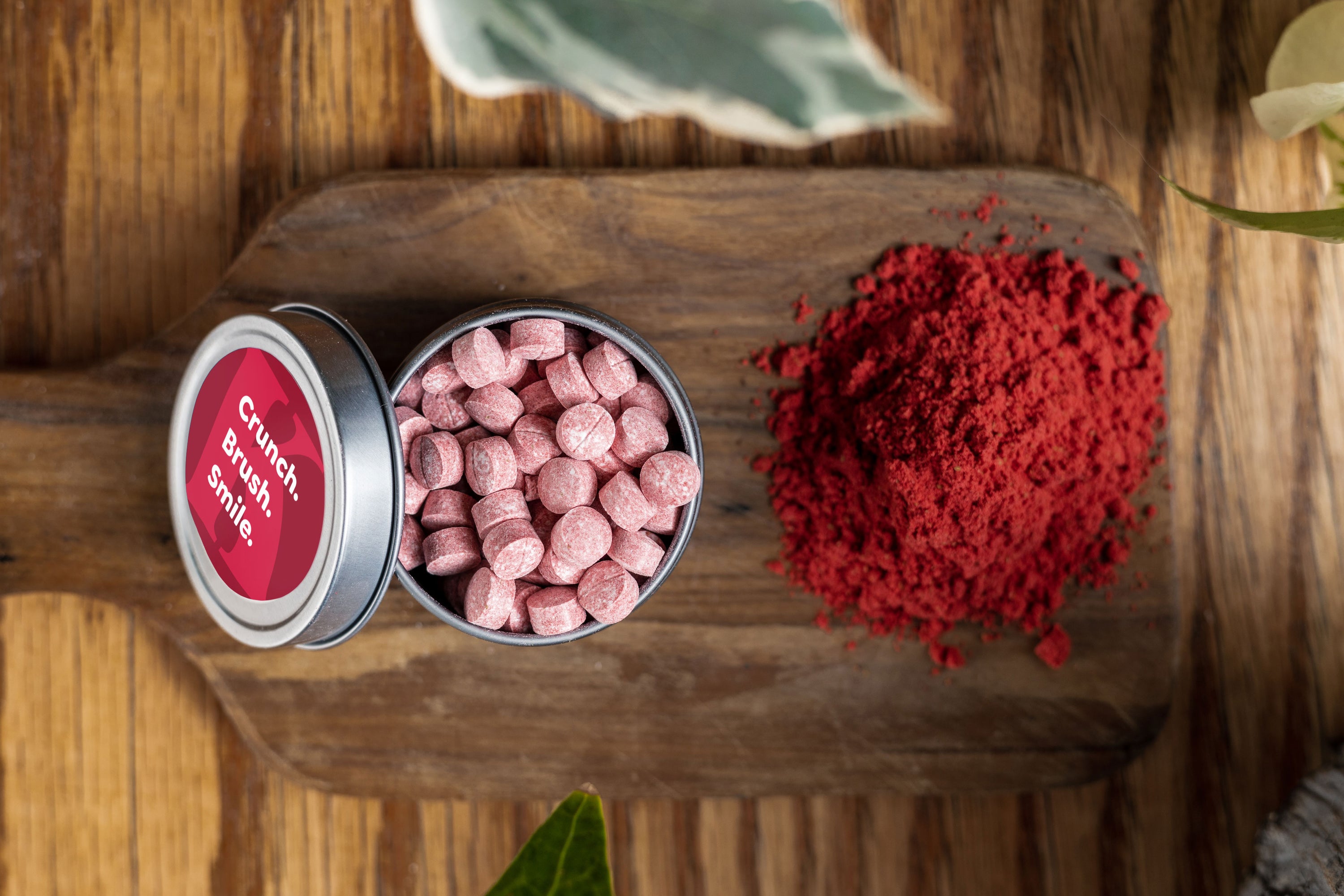 A pack of Strawberry Toothpaste Tablets featuring vibrant packaging and a few tablets scattered around, showcasing their unique shape and color.