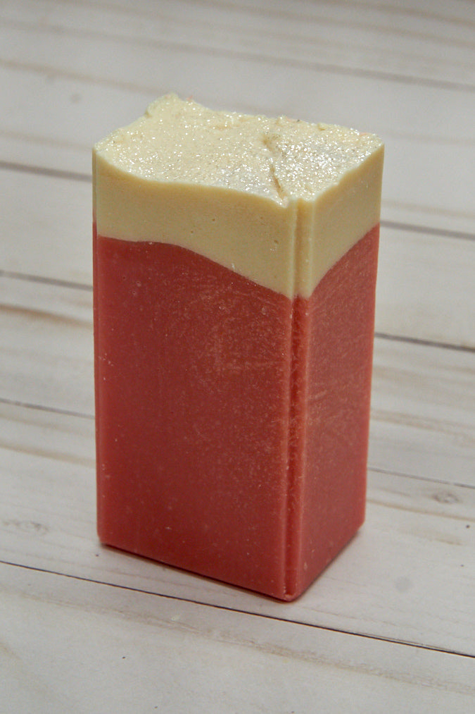 A vibrant bar of Sugared Strawberry Soap with a rich pink color, adorned with eco-friendly glitter, showcasing its handcrafted quality.