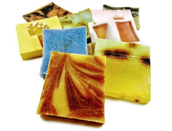 A beautifully arranged Vegan Soap Sampler featuring assorted slices of colorful soap loaf ends tied with a ribbon.