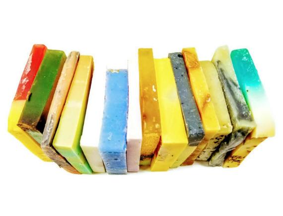 A beautifully arranged Vegan Soap Sampler featuring assorted slices of colorful soap loaf ends tied with a ribbon.