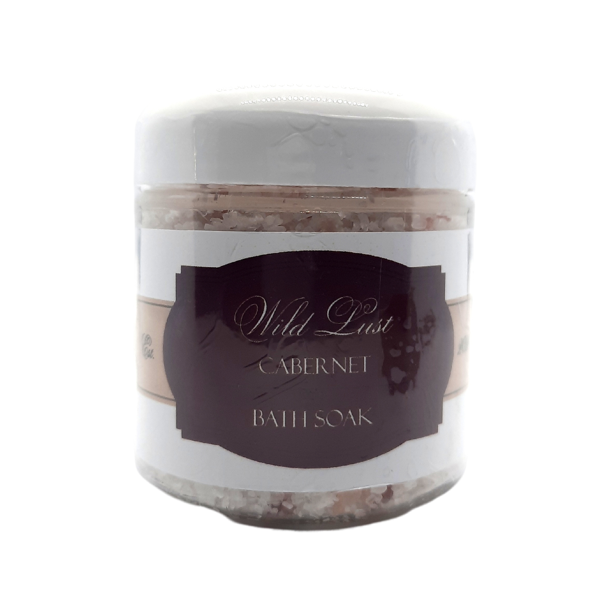 A luxurious bottle of Wild Lust Cabernet Bath Soak surrounded by bath salts and a relaxing spa setting.