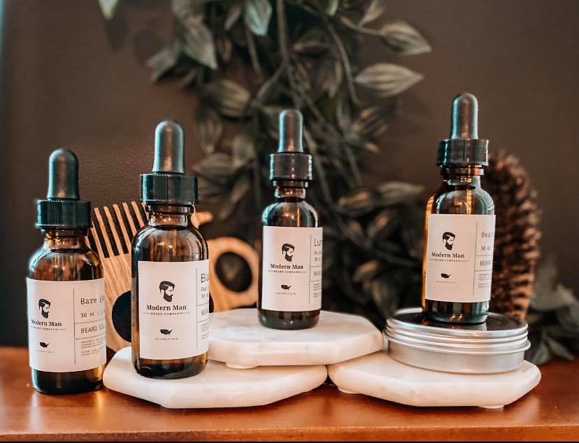 A bottle of Modern Man Beard Company Beard Growth Oil with a dropper, showcasing its premium all-natural ingredients for beard growth.