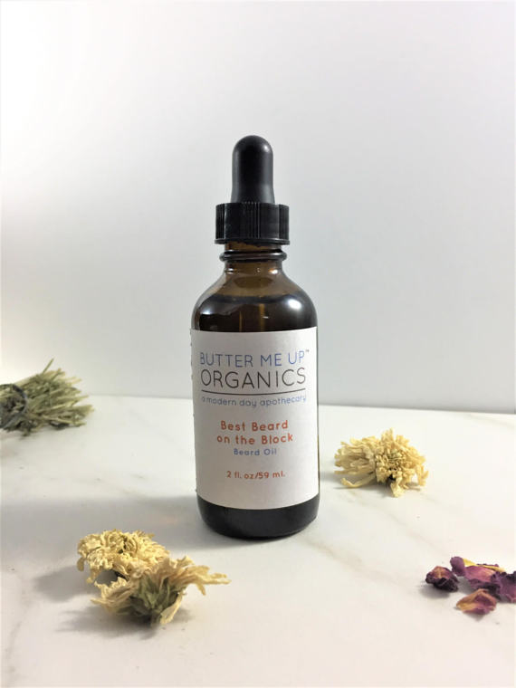 A 2oz glass jar of Best Beard On The Block Organic Beard Oil, showcasing its rich, golden color and labeled with organic ingredients for beard care.