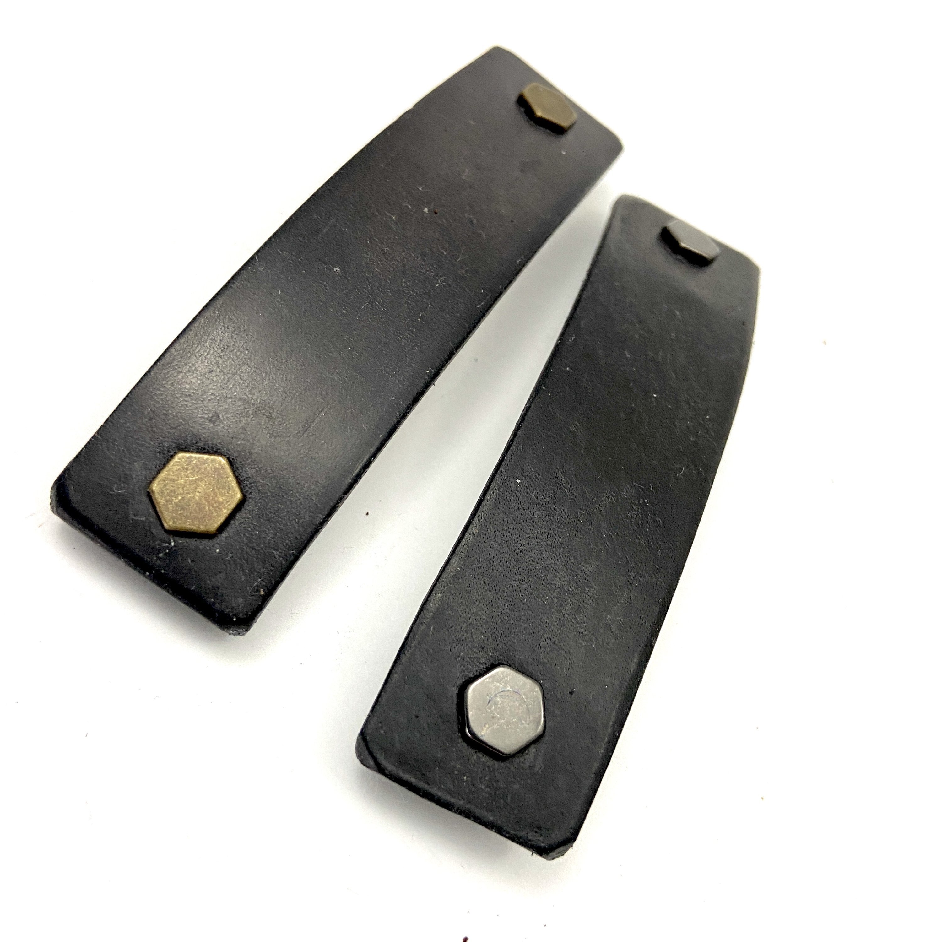 Black leather barrette with industrial hex hardware, showcasing eco-friendly design and sturdy metal clip.