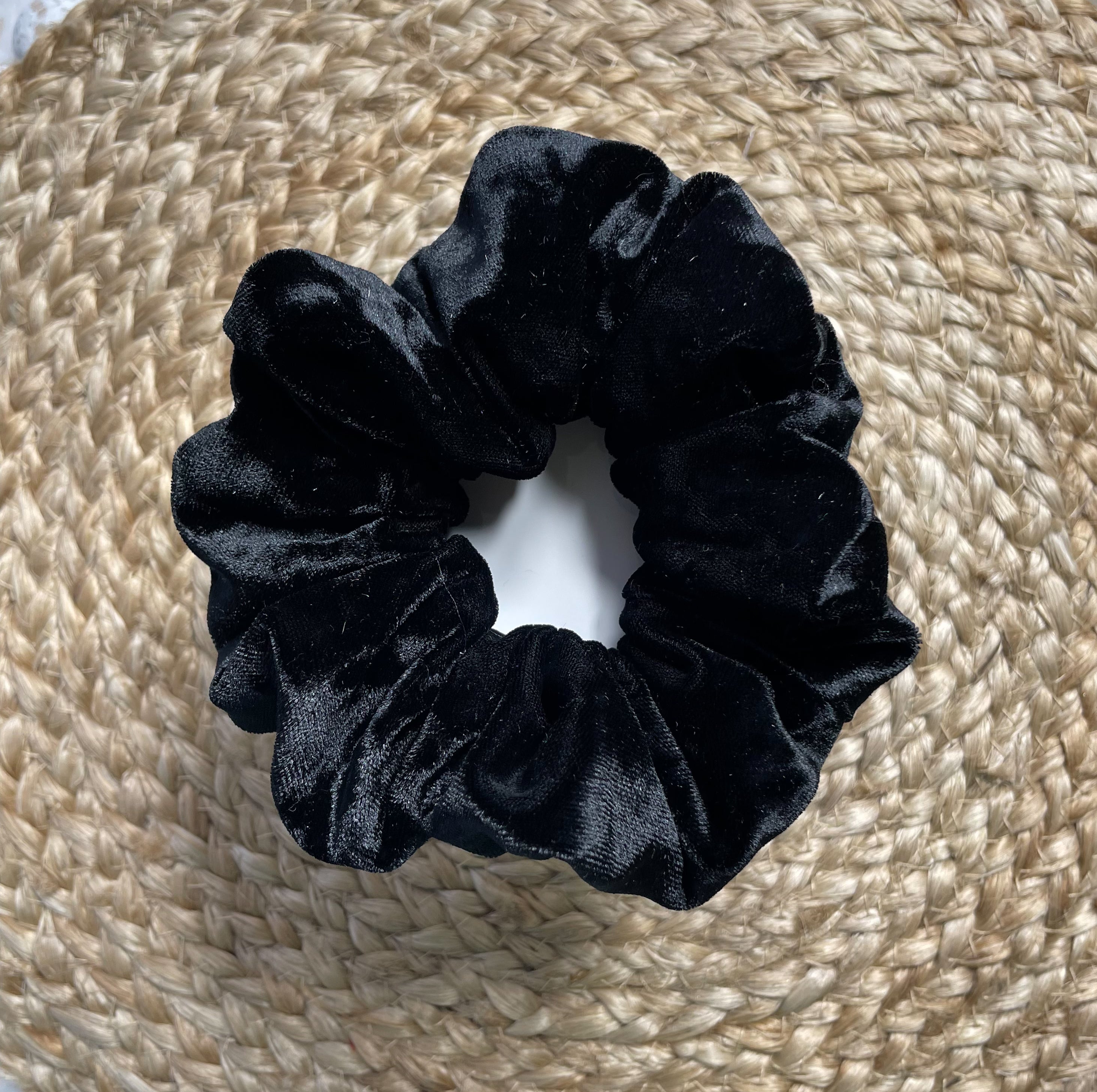 A luxurious black velvet scrunchie, handmade with soft texture, perfect for stylish hairdos.