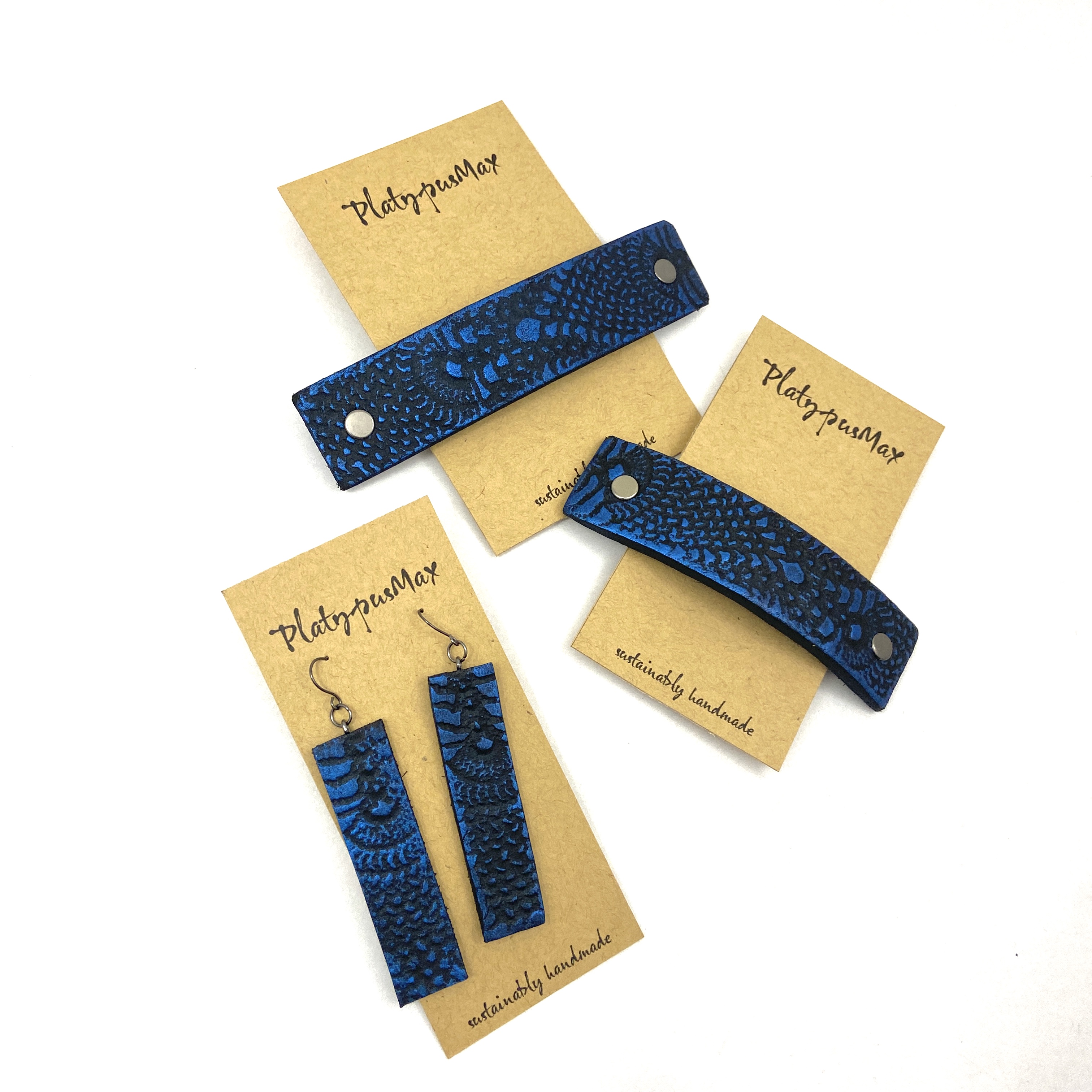 Cobalt blue and black lace texture barrette and earring gift set, showcasing unique leather craftsmanship and vibrant colors.