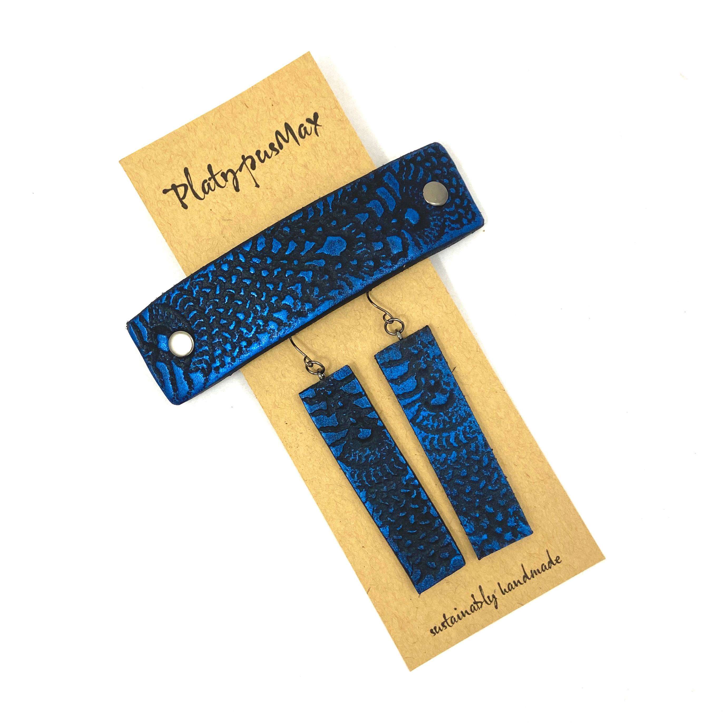 Cobalt blue and black lace texture barrette and earring gift set, showcasing unique leather craftsmanship and vibrant colors.