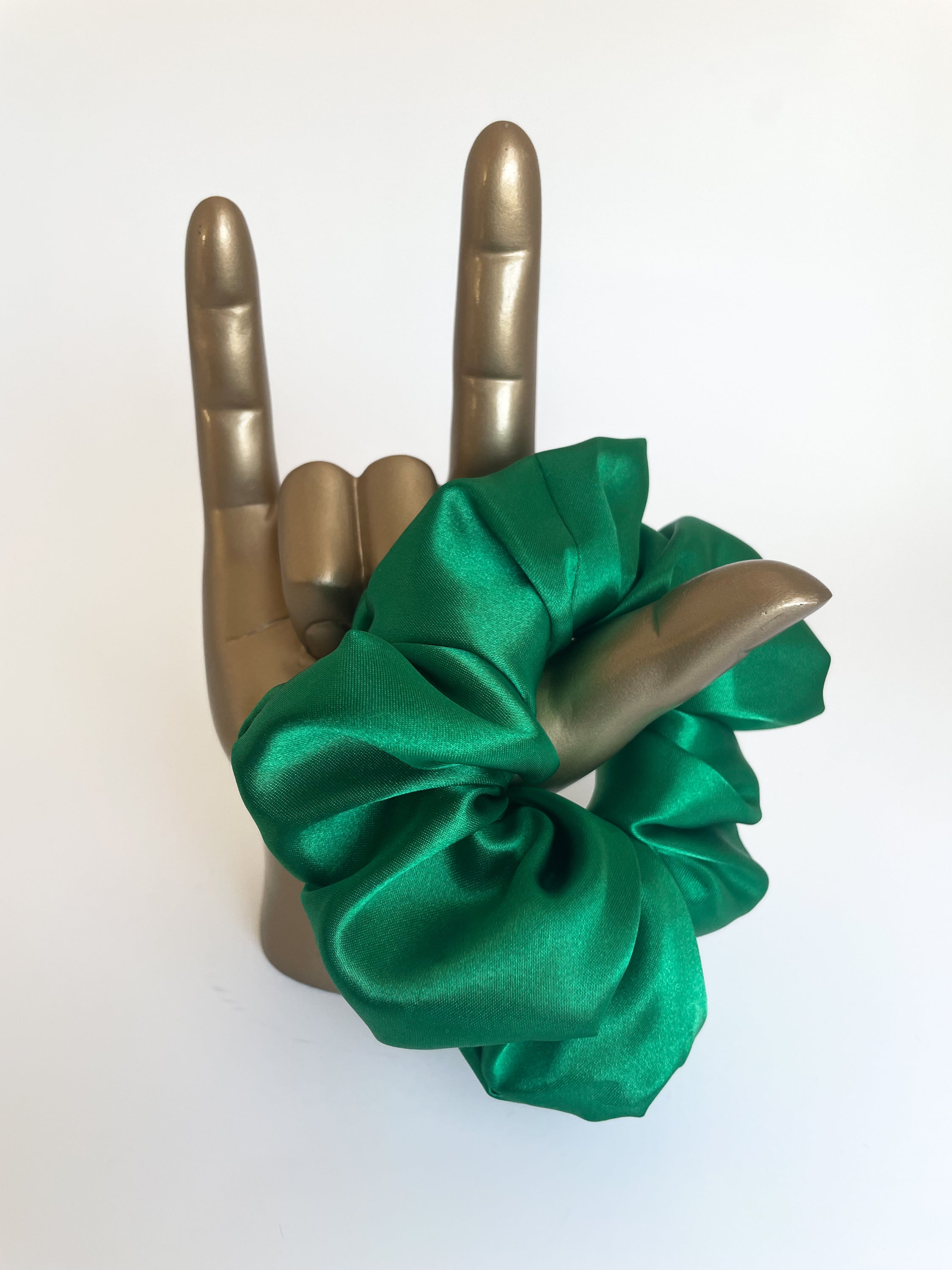 Emerald satin scrunchie with a luxurious sheen, perfect for stylish hairdos.