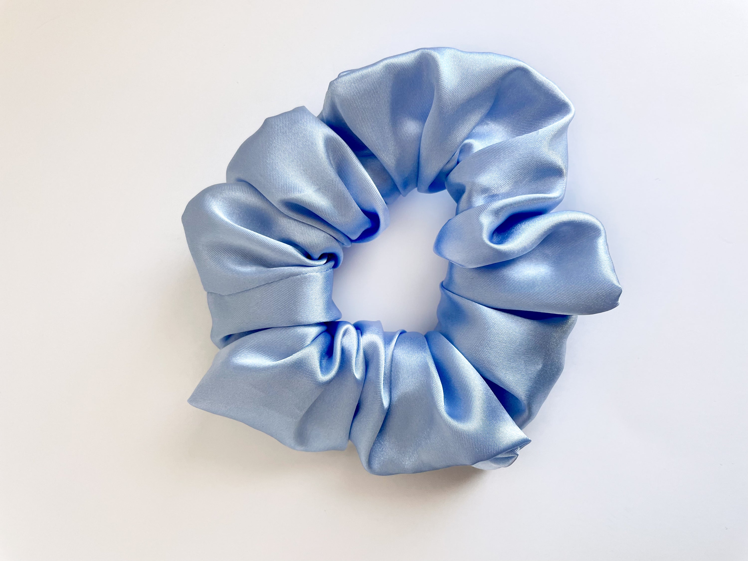 Frost satin scrunchie in a soft, elegant design, showcasing its luxurious texture and stylish appearance.