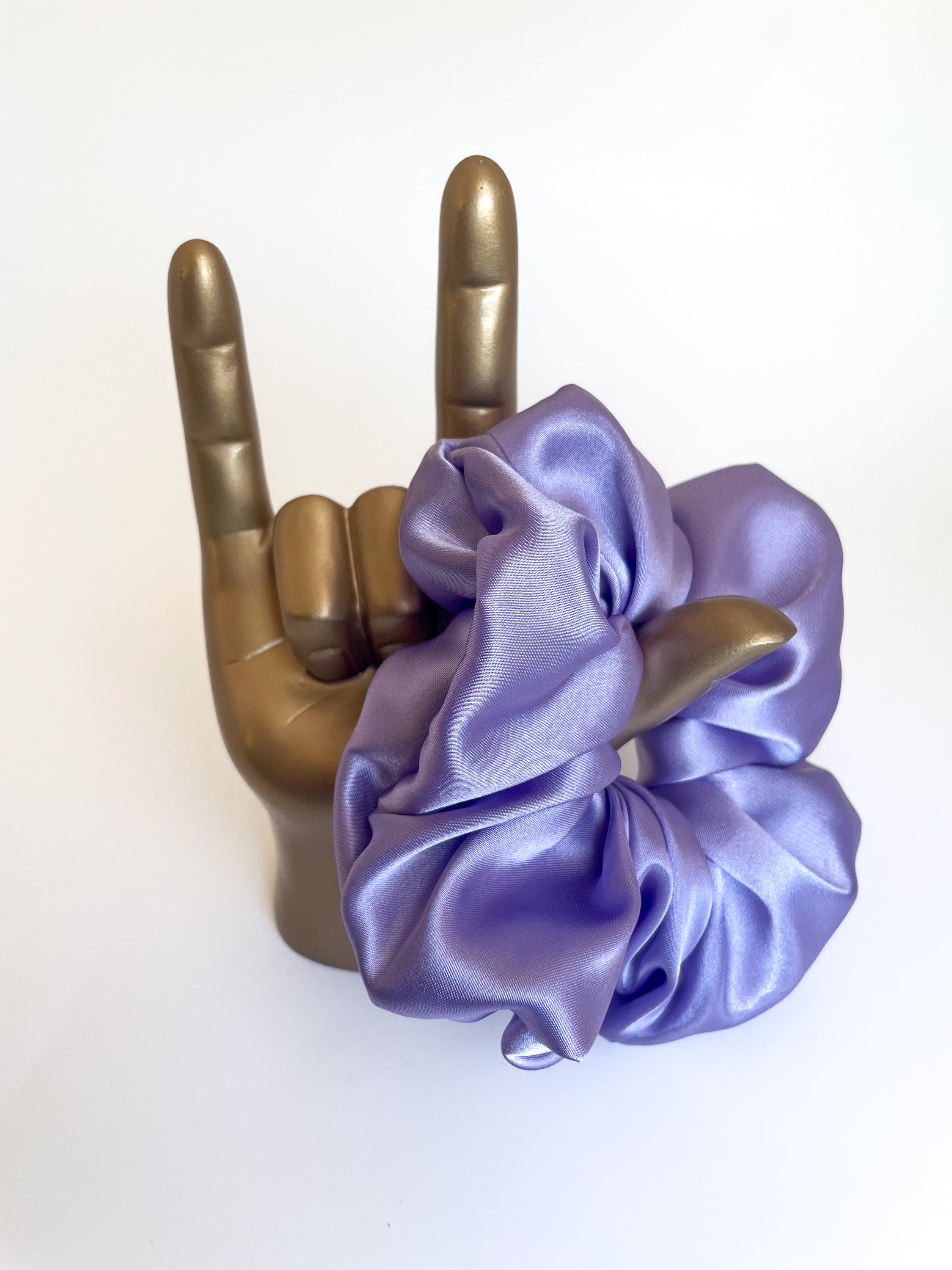 Lilac satin scrunchie elegantly displayed, showcasing its smooth texture and vibrant color.