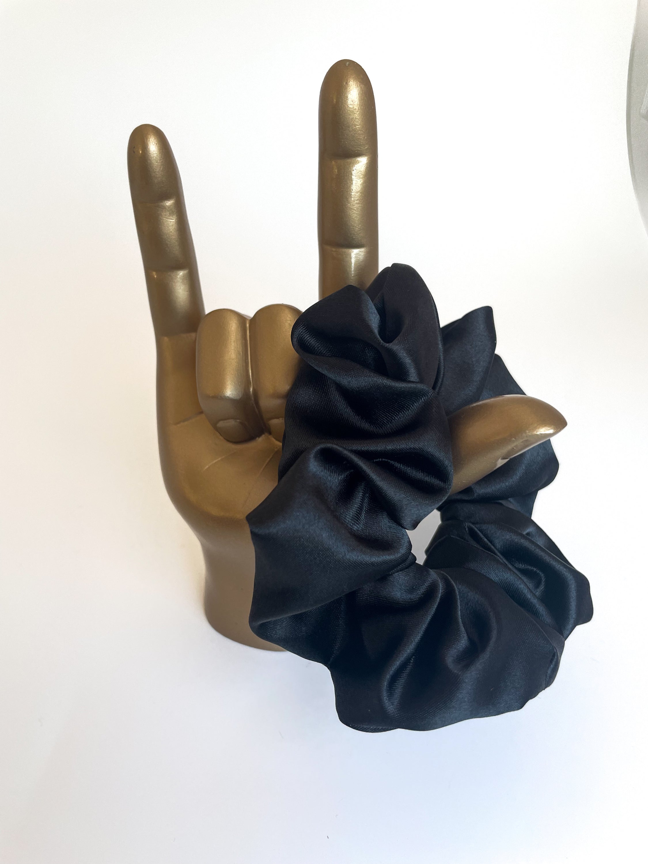 Midnight black satin scrunchie elegantly displayed, showcasing its smooth texture and luxurious appearance.