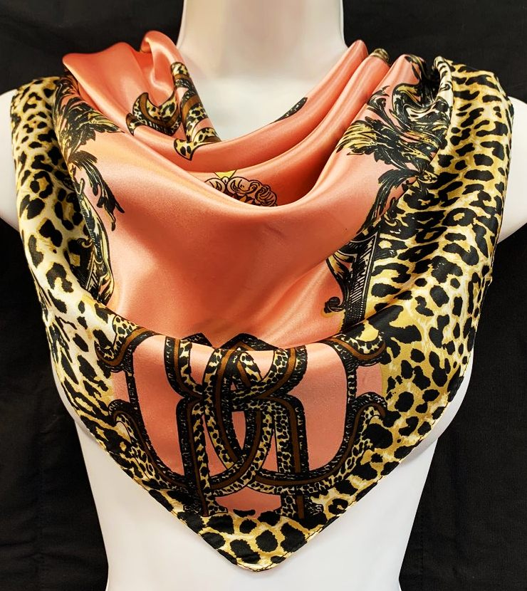 A luxurious 35x35 inch multi-purpose scarf made of soft polyester, styled as a hair scarf and displayed elegantly.