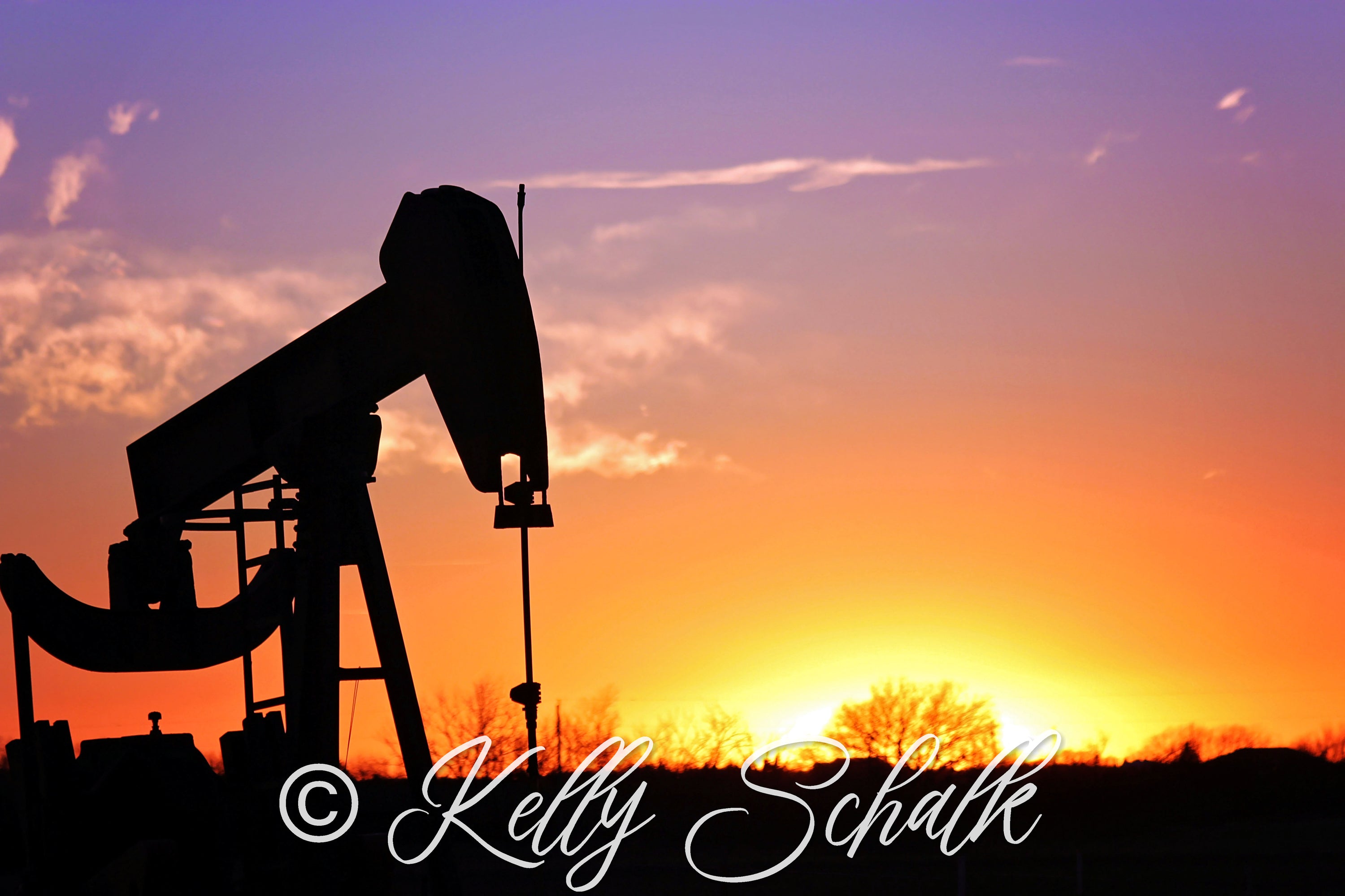 A vibrant photo print of a pump jack, showcasing its mechanical structure against a clear sky.