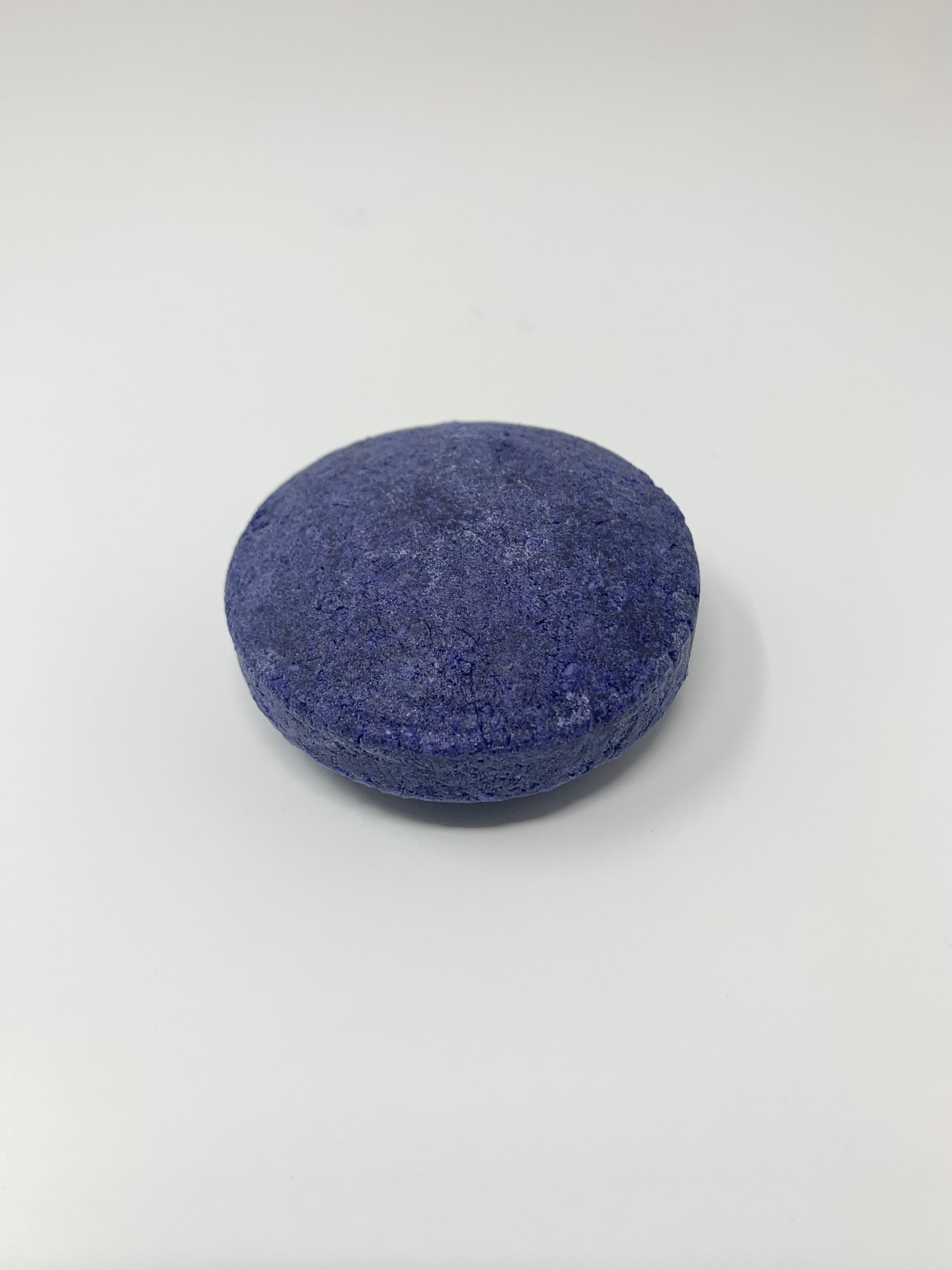 A vibrant PURPLE-toning shampoo bar designed to neutralize brassy tones in blonde hair, resting on a natural wooden surface.