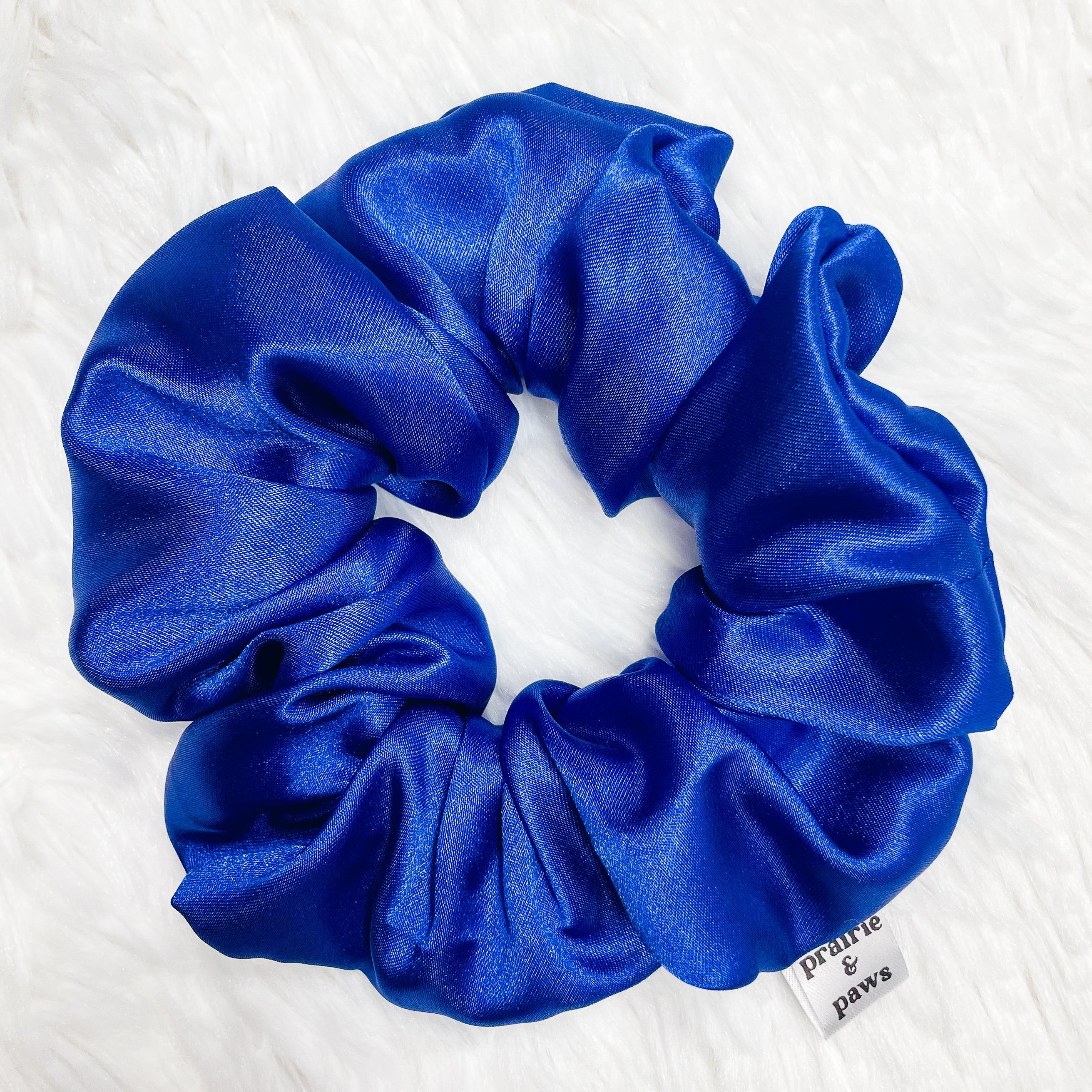 A luxurious royal blue satin scrunchie, perfect for stylish hairdos.