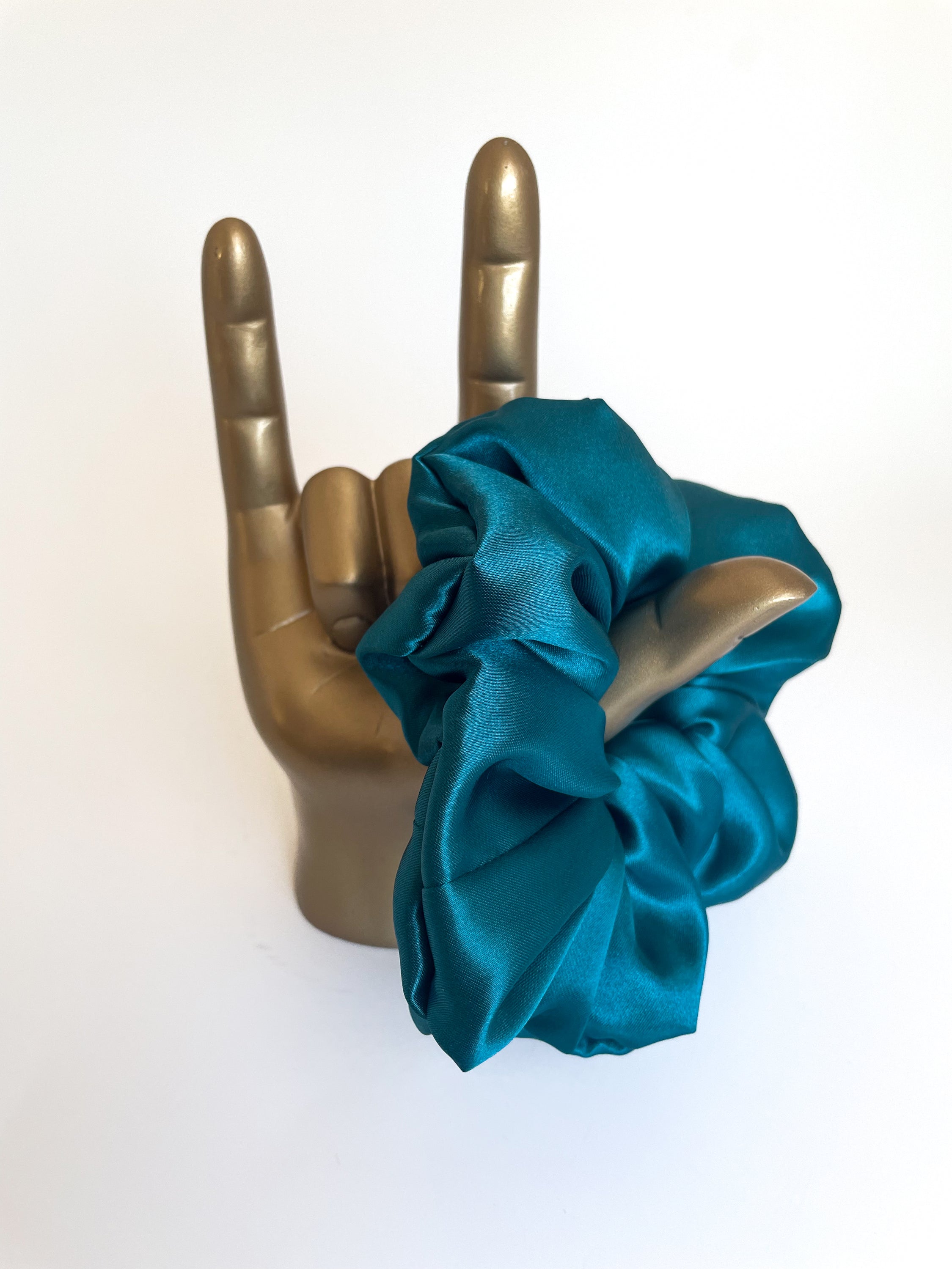 A luxurious sapphire satin scrunchie, elegantly styled and perfect for all hair types.