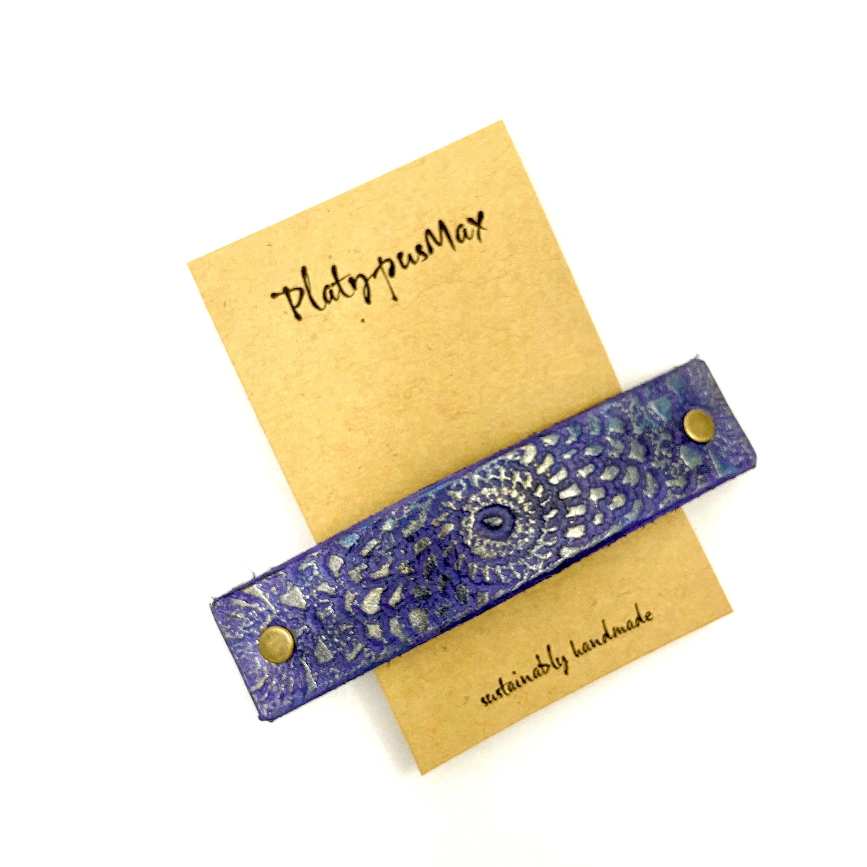 Shimmery purple and gold embossed mandala leather hair barrette with intricate vintage lace pattern.