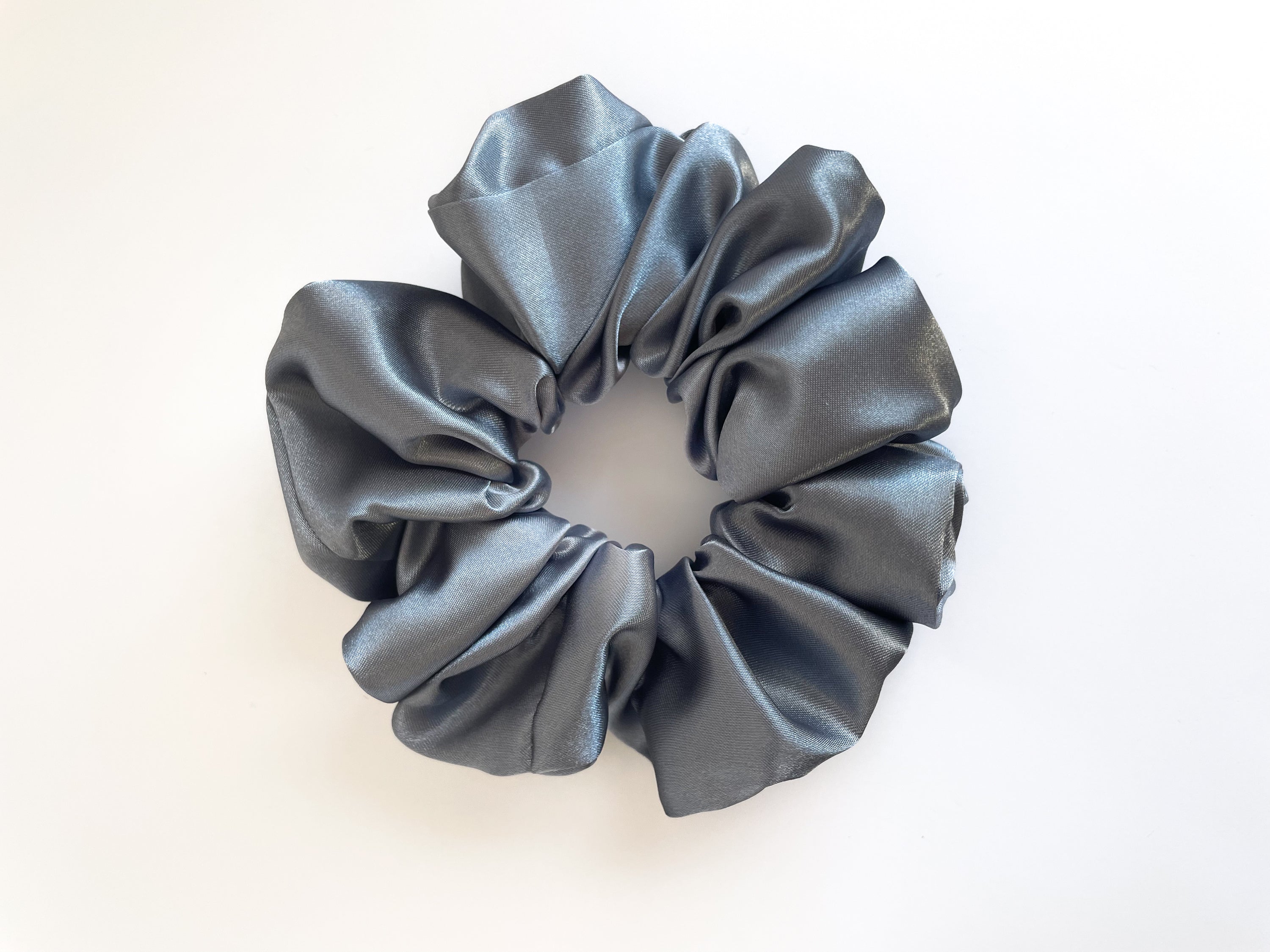 A luxurious Sterling satin scrunchie in various colors, showcasing its smooth texture and elegant design, perfect for stylish hair management.