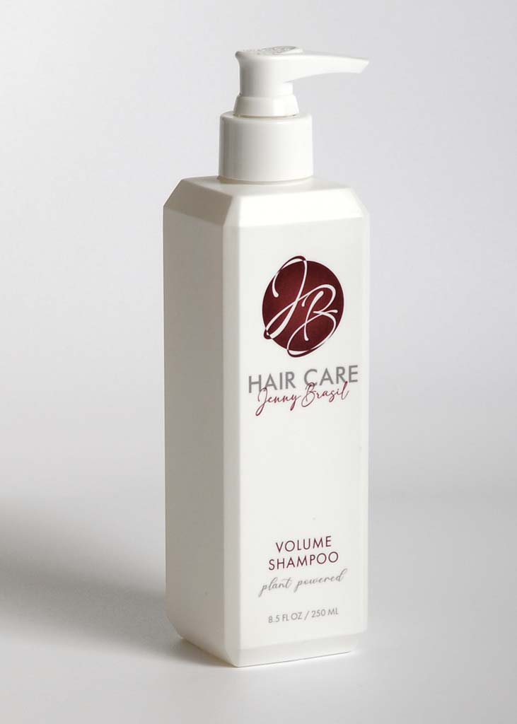 A bottle of Volume Shampoo with a sleek design, showcasing its nourishing ingredients like quinoa protein and bentonite clay.