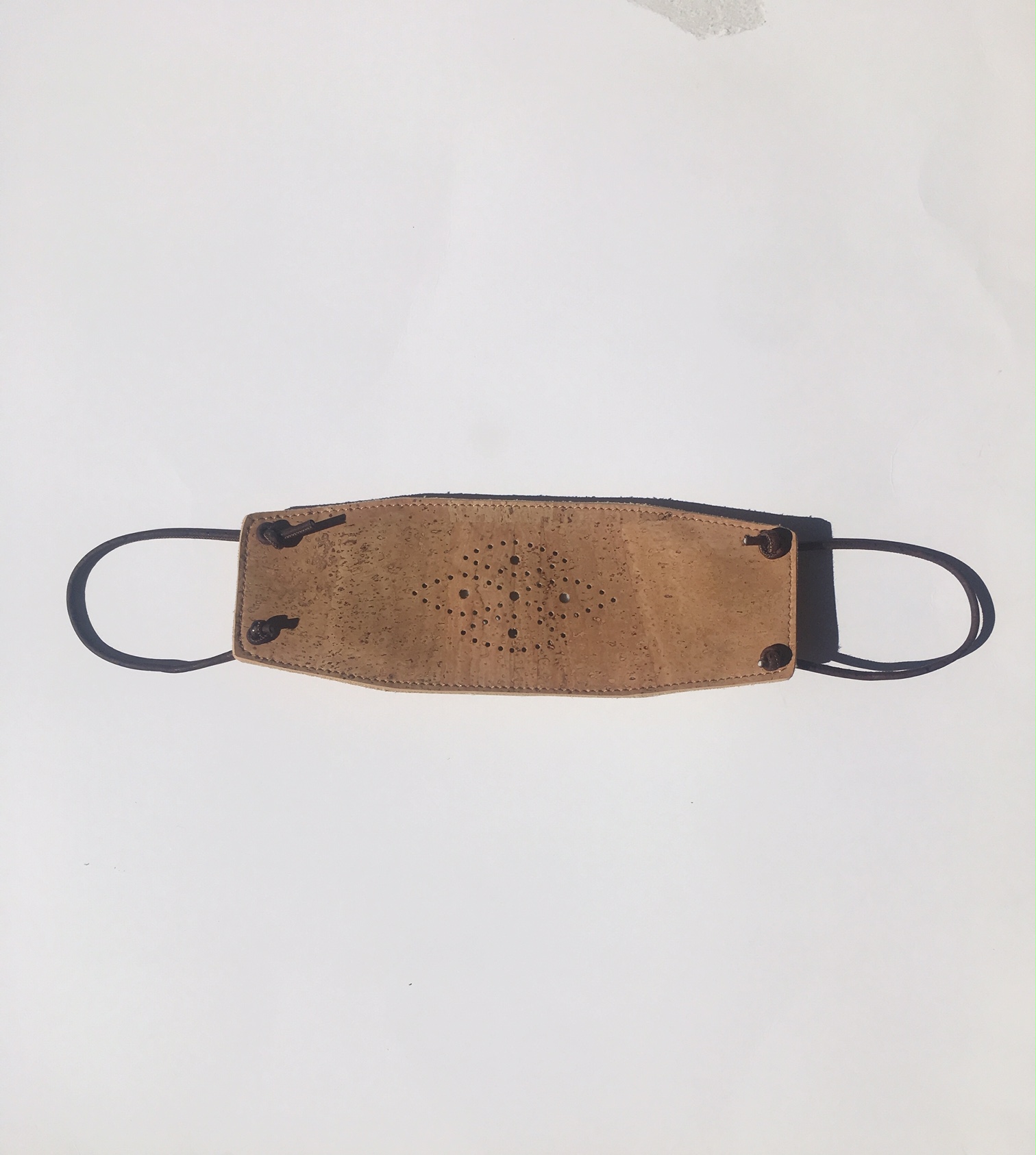 Eco-friendly cork face mask with adjustable ear loops, showcasing its lightweight and breathable design.