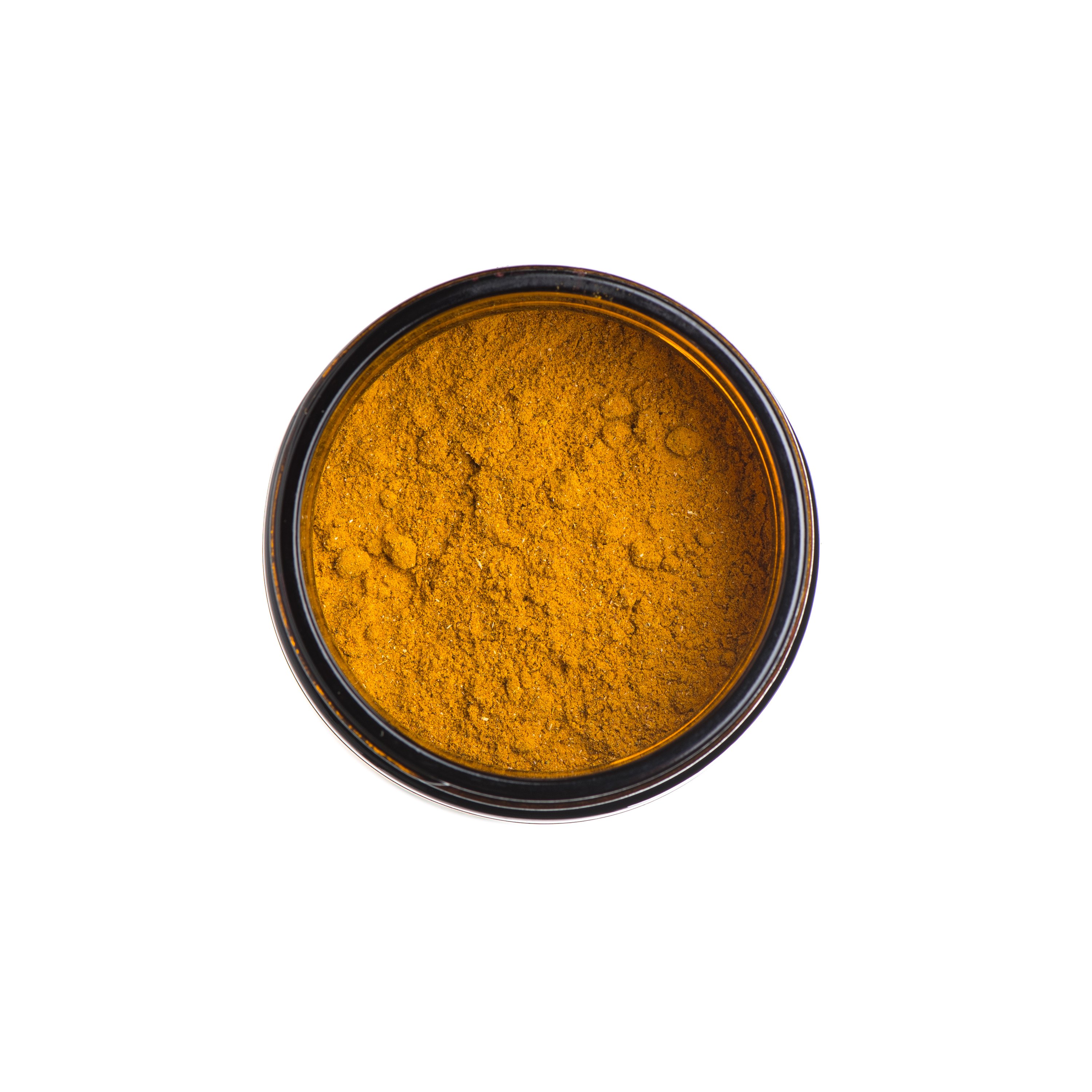 A glass jar of Golden Milk powder with a golden hue, surrounded by turmeric roots and spices, showcasing its Ayurvedic ingredients.