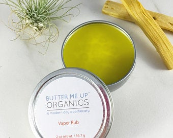 A 2 oz. tin of Handmade Organic Vapor Rub featuring a blend of essential oils, olive oil, and beeswax, promoting natural relief from congestion.