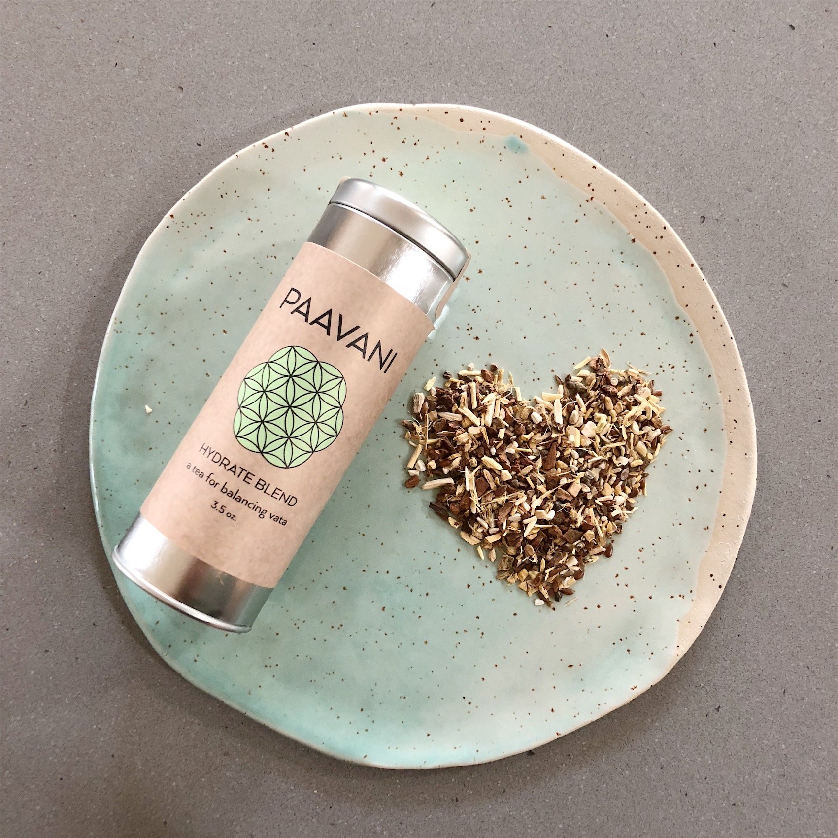 A metal canister of Hydrate Blend Tea featuring Ayurvedic herbs like Ashwagandha, Shatavari, Licorice, and Cinnamon, designed for hydration and wellness.