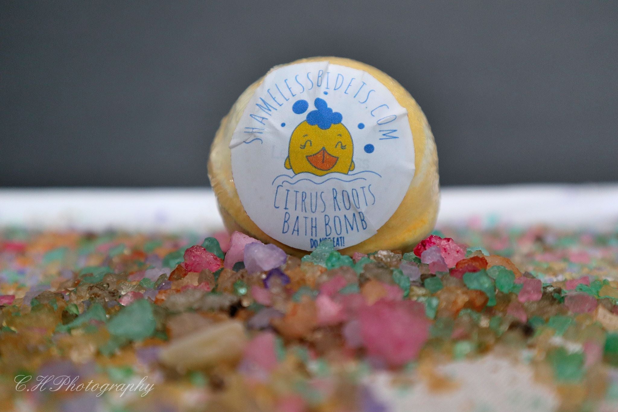 Yellow bath bomb on colorful crystals.