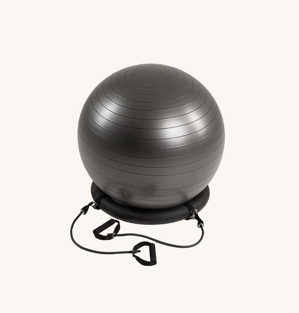 A vibrant Pilates ball with attached resistance bands, ideal for yoga and fitness exercises, placed on a gym mat.