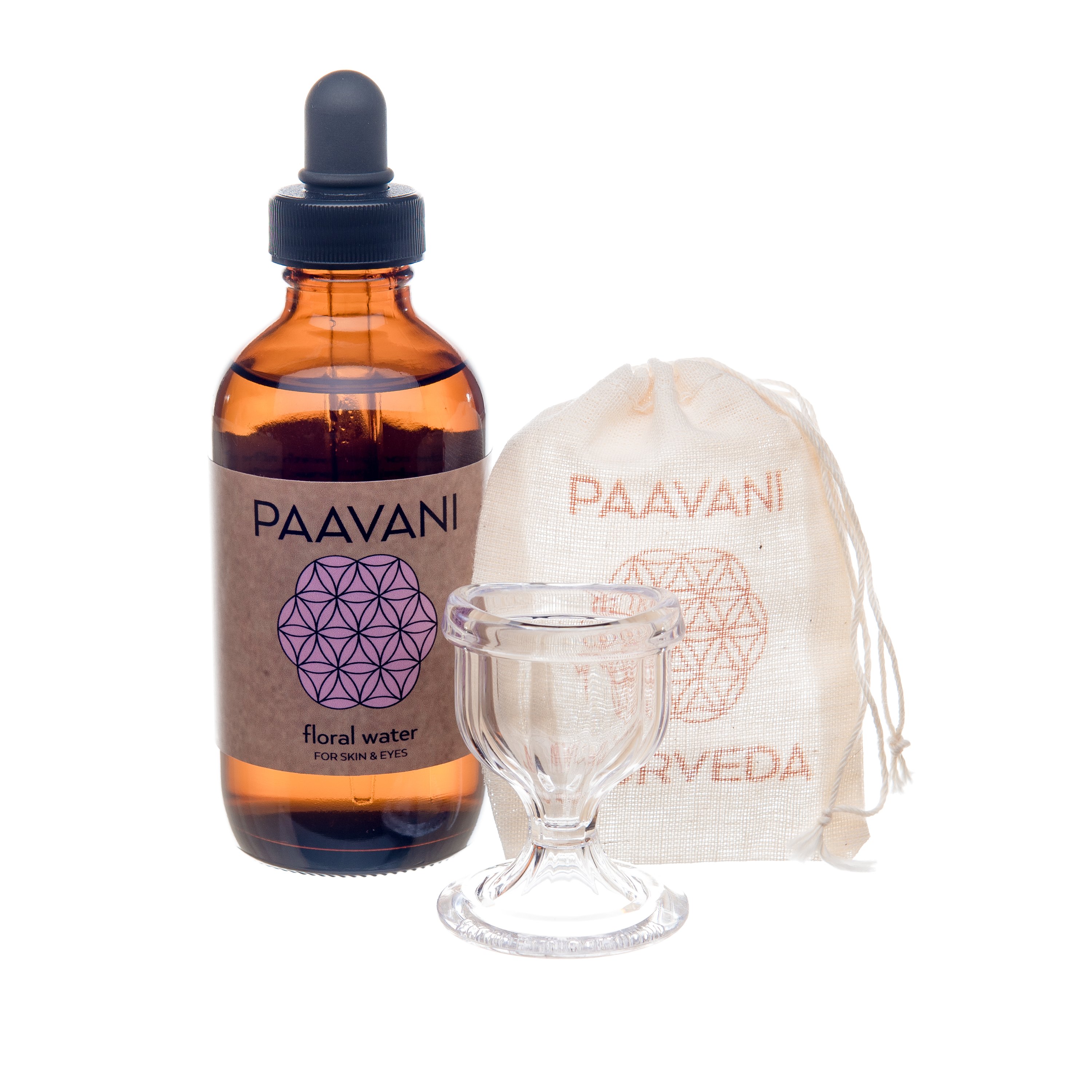 A soothing eye wash ritual kit featuring floral water, a glass eye wash cup, and a muslin travel pouch, designed for eye health and rejuvenation.