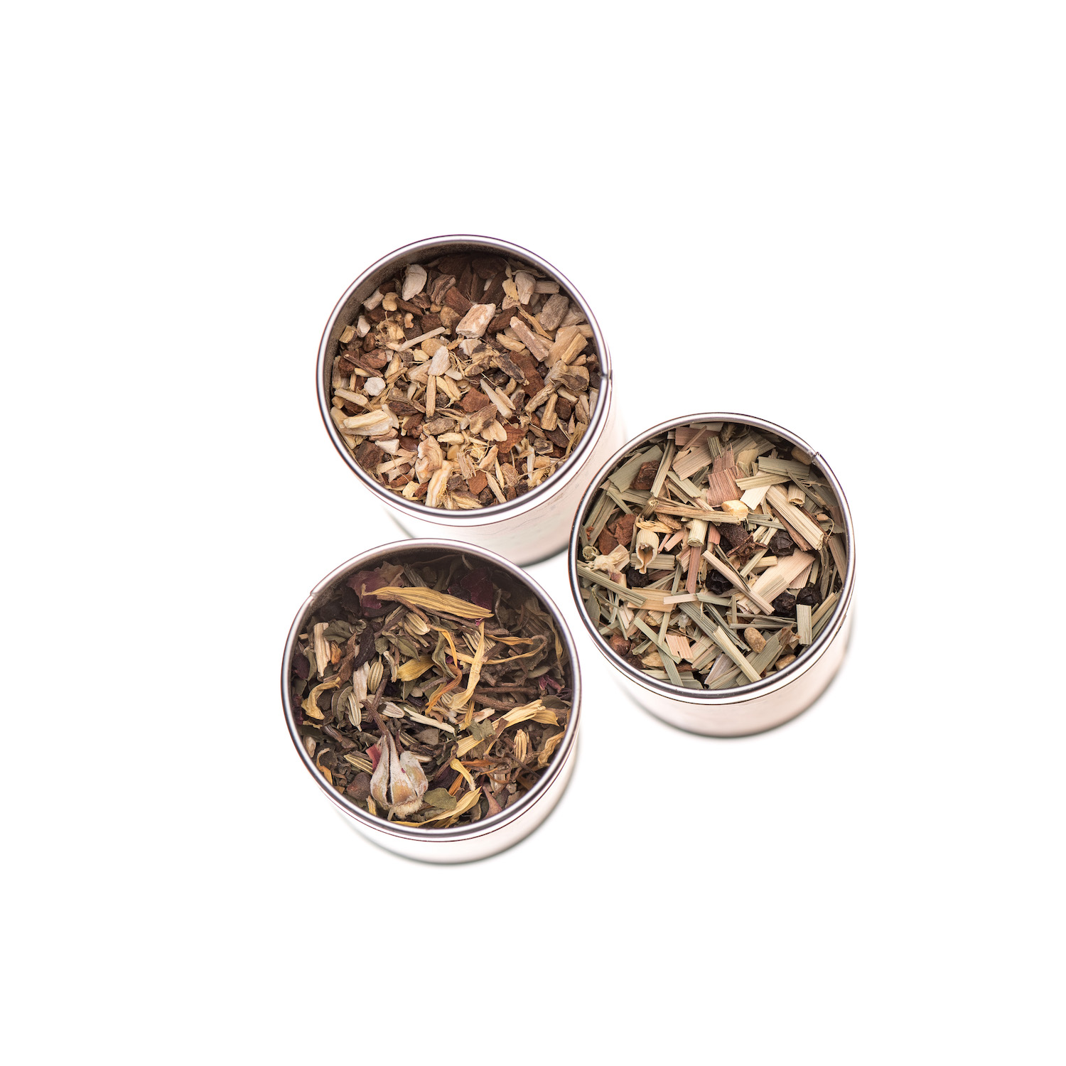 A collection of three herbal tea blends in metal canisters, showcasing organic ingredients and Ayurvedic healing properties.