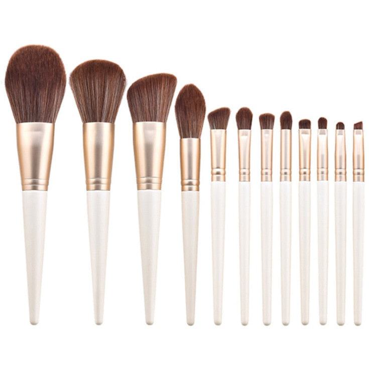 A set of 12 makeup brushes with soft bristles and wooden handles in green and white colors, ideal for foundation and eye shadow application.