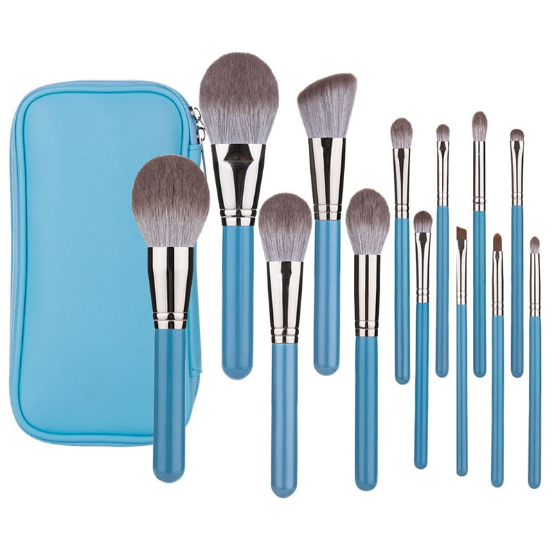 A complete set of 13 blue makeup brushes displayed in a leather tool belt, showcasing various brush types for face, eyes, and lips.