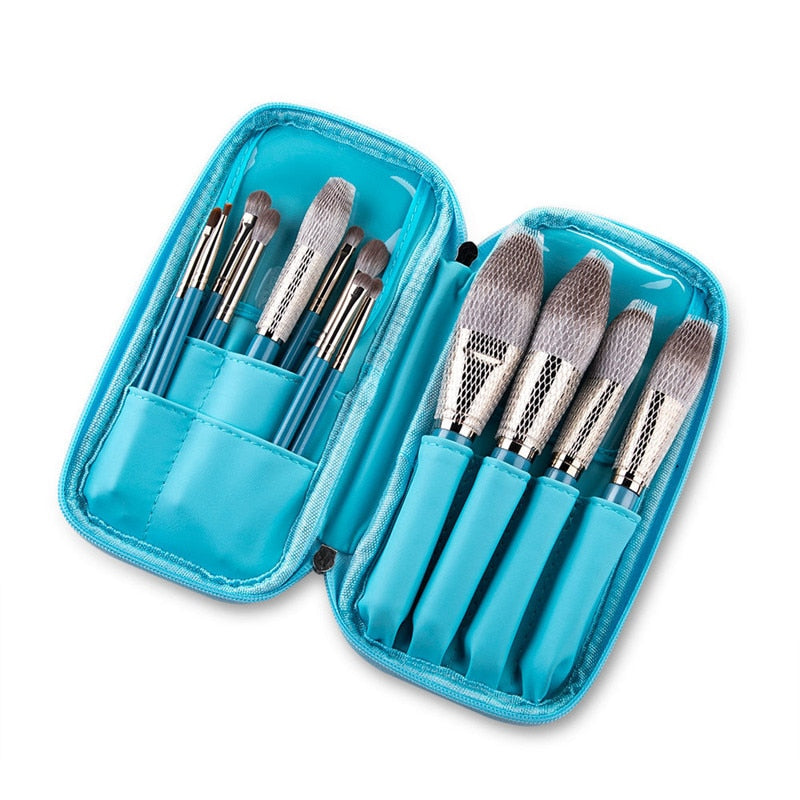 A complete set of 13 blue makeup brushes displayed in a leather tool belt, showcasing various brush types for face, eyes, and lips.