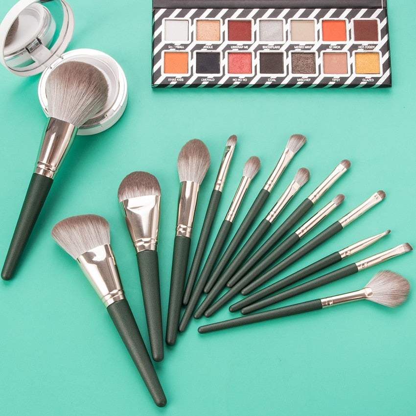 14-piece Green Cloud Makeup Brushes Set with wooden handles and nylon bristles, neatly arranged in a leather bag.