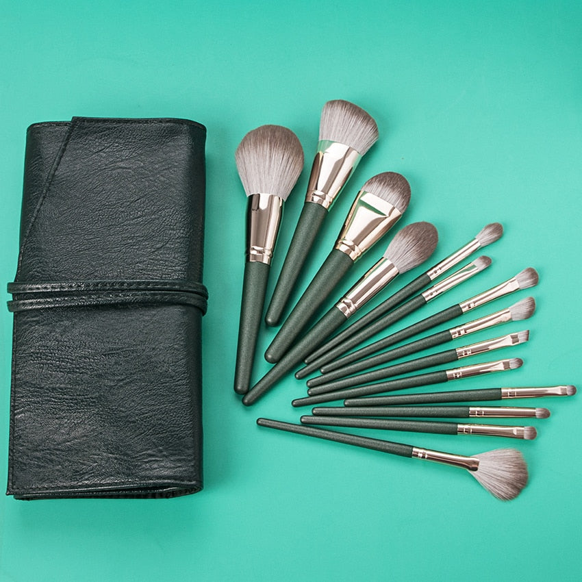 14-piece Green Cloud Makeup Brushes Set with wooden handles and nylon bristles, neatly arranged in a leather bag.