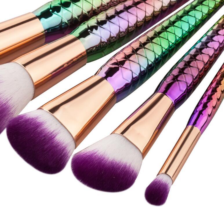 A set of 5 mermaid-themed makeup brushes with colorful handles and soft bristles, perfect for makeup application.