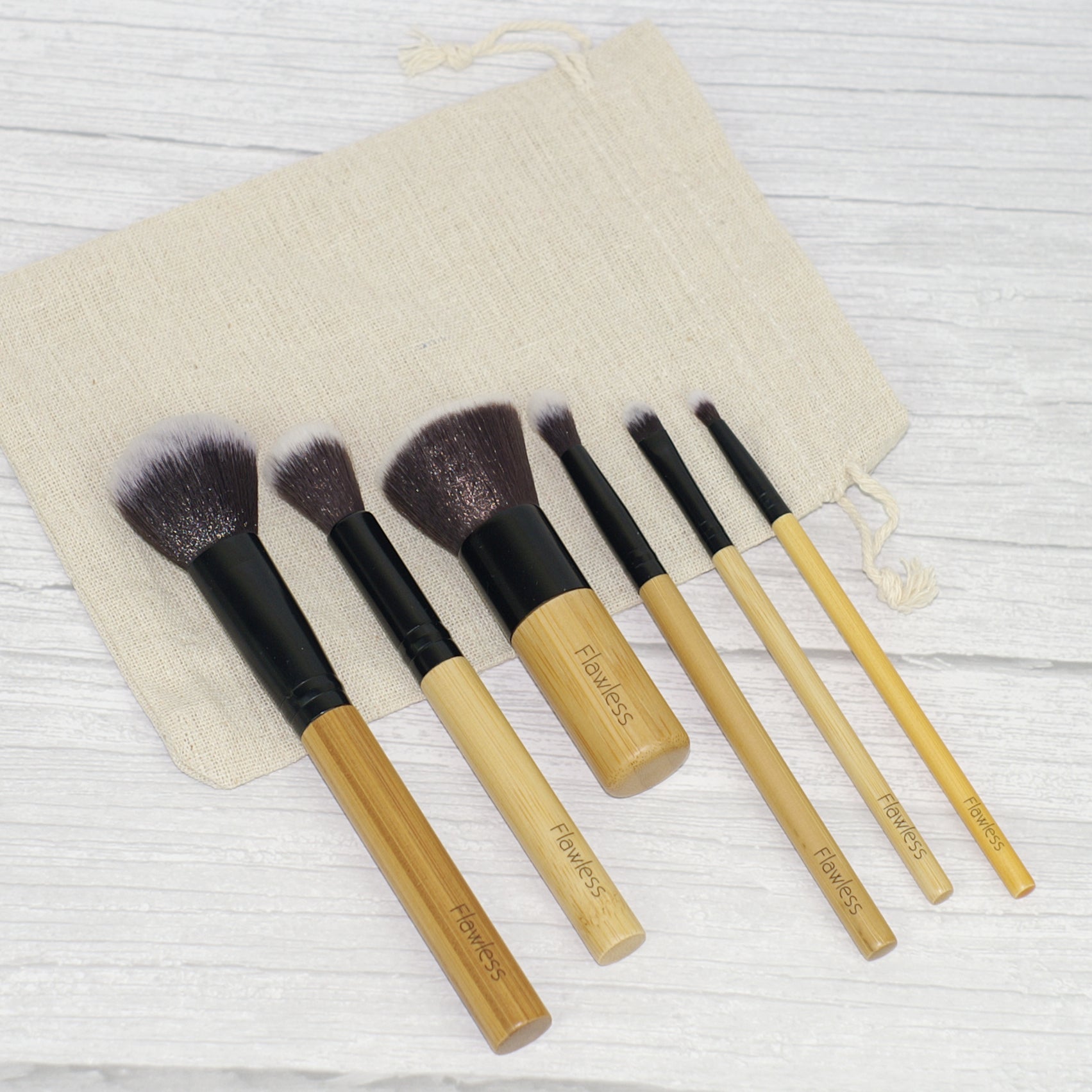 Dewy Skin Bamboo Brush Set featuring six soft brushes with bamboo handles and an organic cotton storage bag.