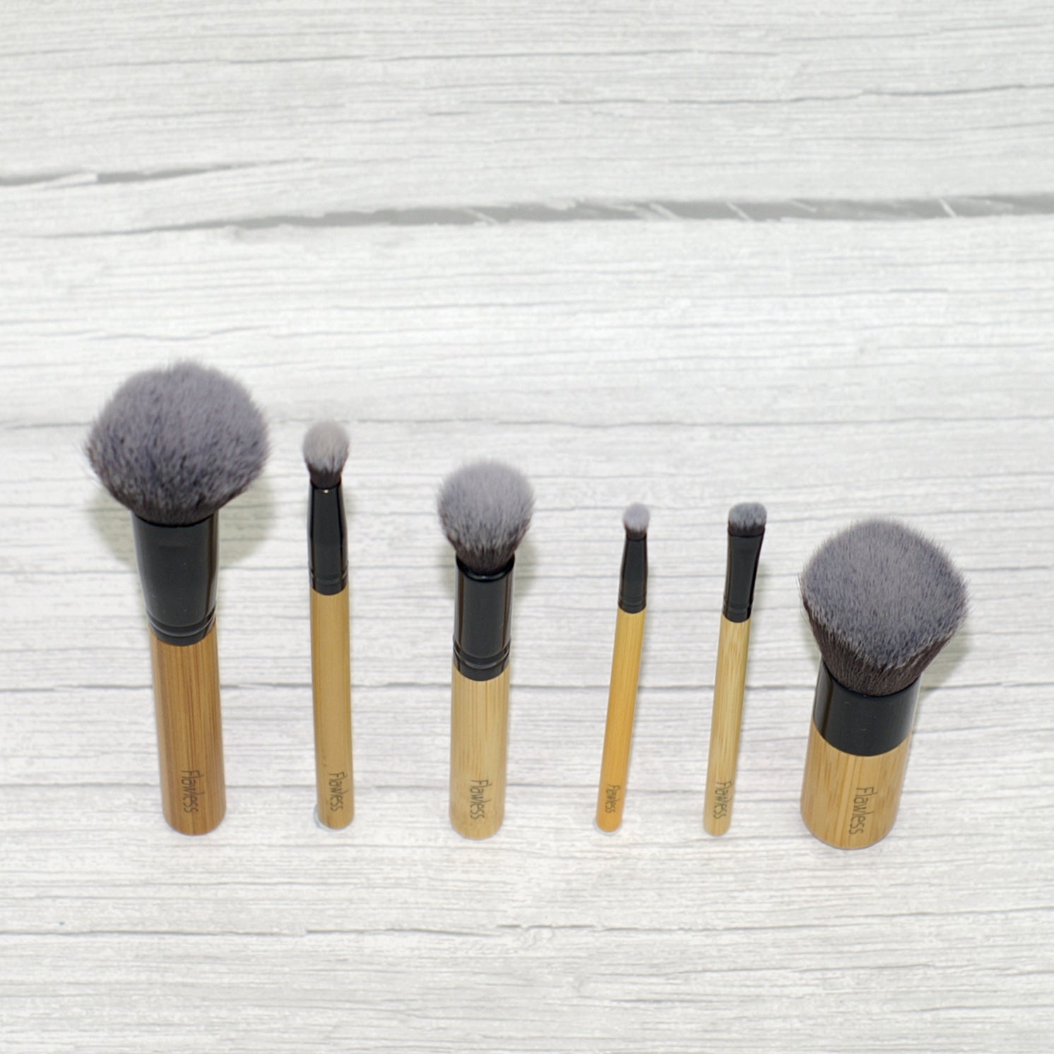 Dewy Skin Bamboo Brush Set featuring six soft brushes with bamboo handles and an organic cotton storage bag.