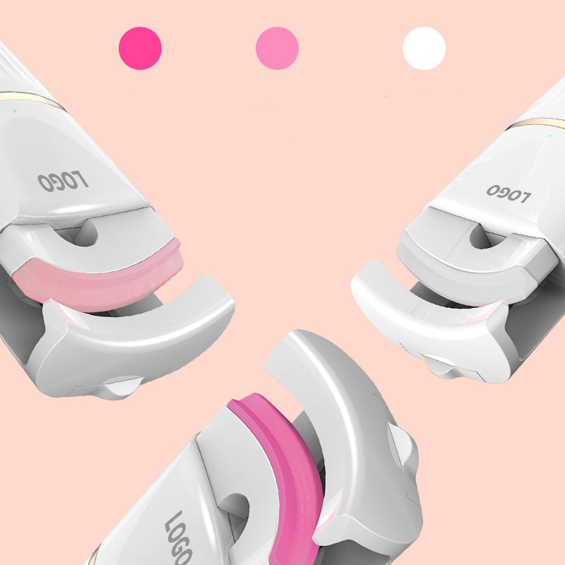 Electric eyelash curler in white, pink, and blue colors, showcasing its sleek design and compact size.