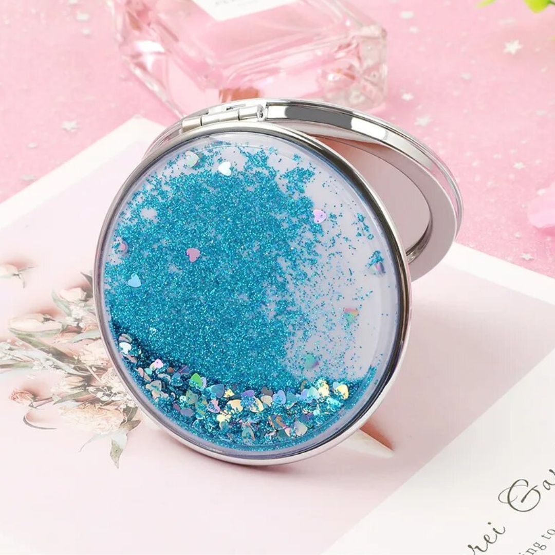 A stylish double-sided portable mirror featuring glitter quicksand design, showcasing both 1x and 2x magnification options.