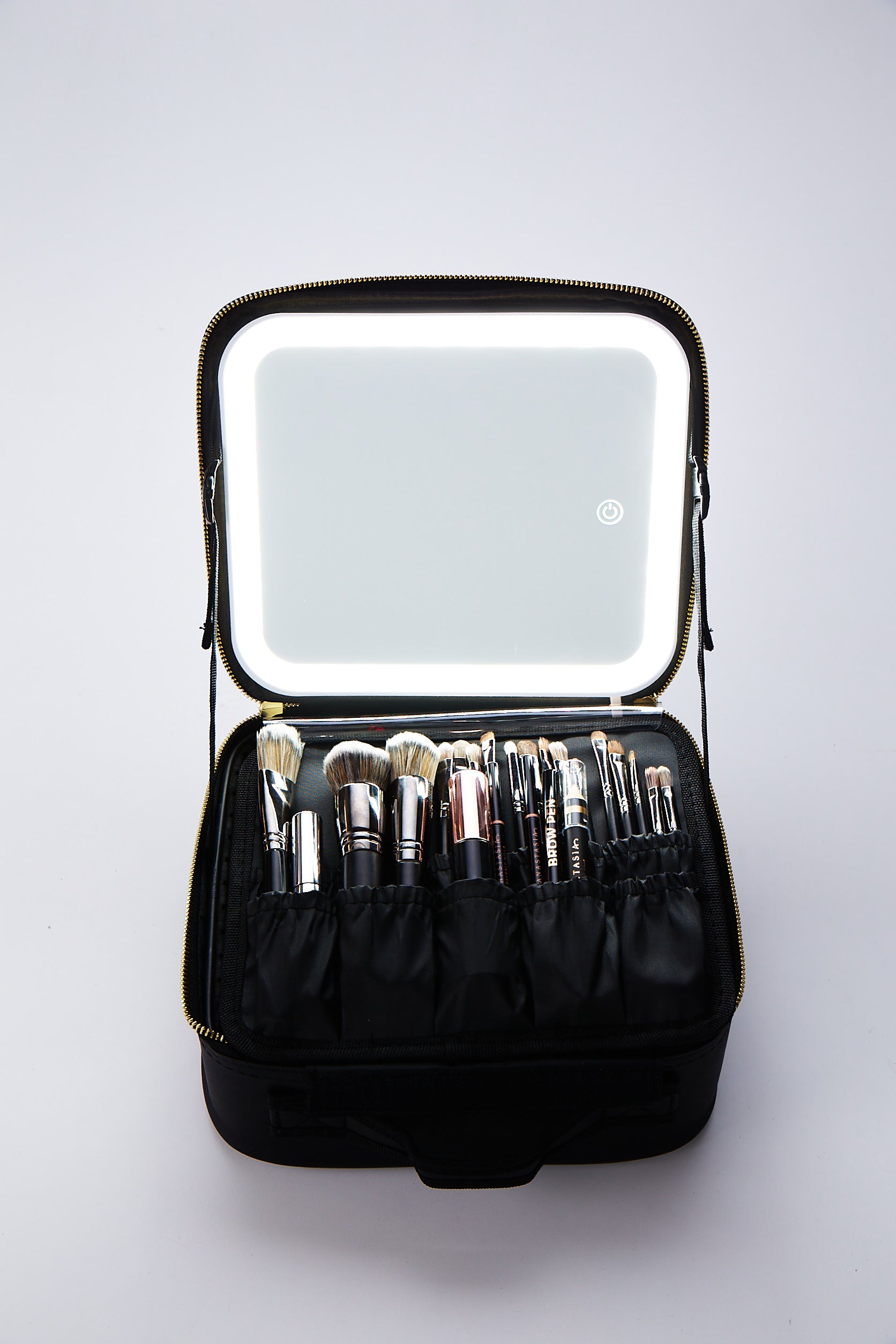 Illuminate Beauty Case featuring adjustable mirror, USB charging, and organized compartments in black and white with gold zippers.