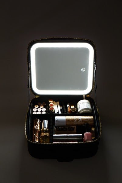 Illuminate Beauty Case featuring adjustable mirror, USB charging, and organized compartments in black and white with gold zippers.