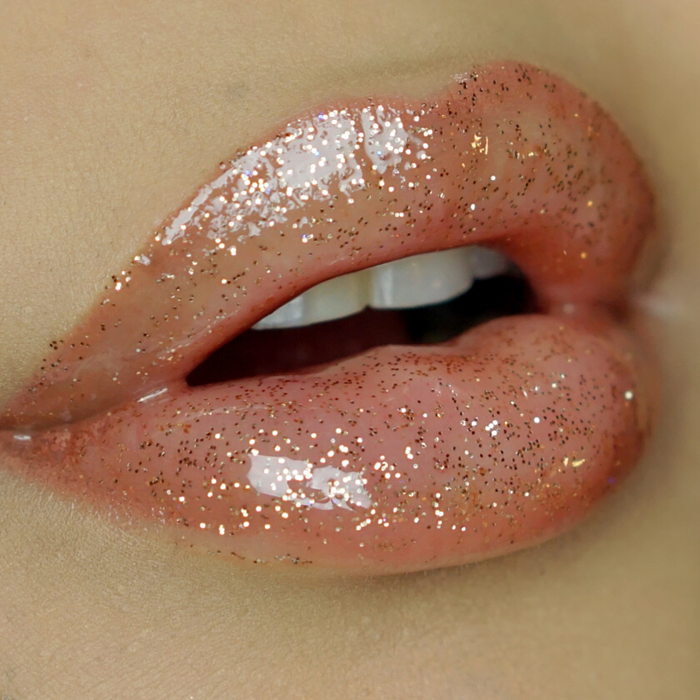 A luxurious tube of Million Dollar - XO Royalty Lipgloss featuring a shiny, glittery finish, perfect for glamorous lips.