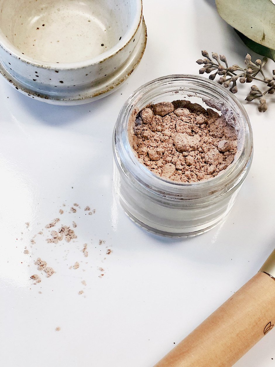 Organic Finishing Powder Setting in a heavyweight glass jar with a metal lid, showcasing its translucent powder and eco-friendly packaging.