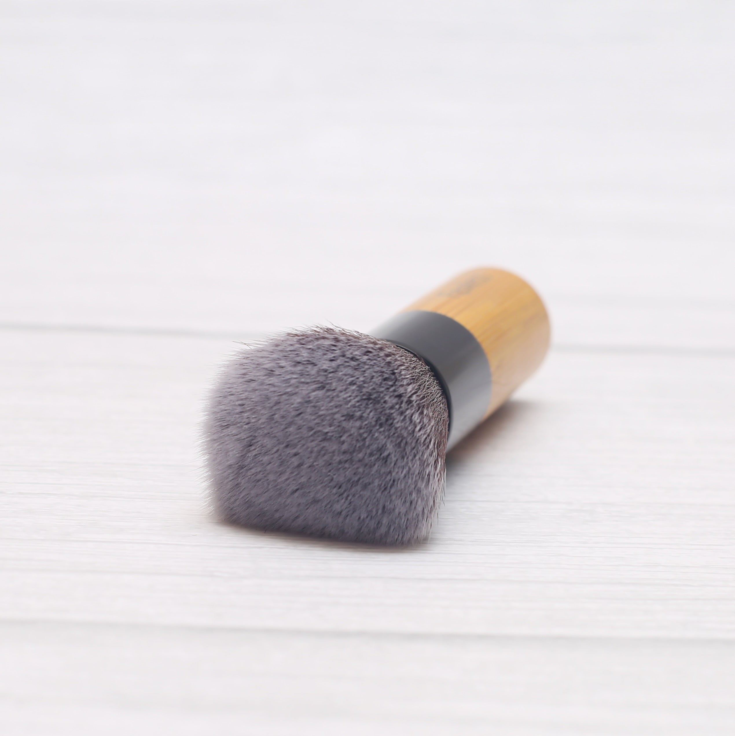 A high-quality Powder/Blusher Brush with a bamboo handle and soft synthetic bristles, ideal for blending powders.