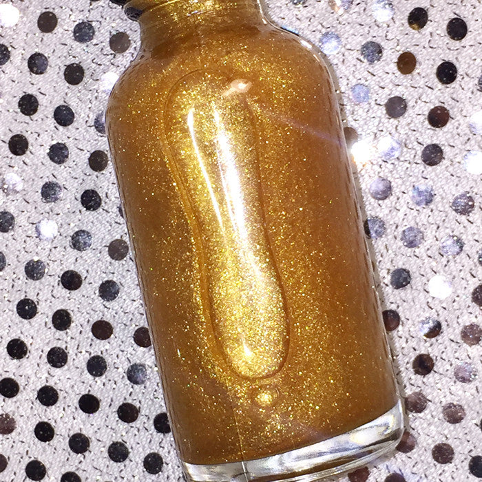 A bottle of Shimmer Dry Oil showcasing its golden luminescence, perfect for nourishing and illuminating skin, hair, and face.