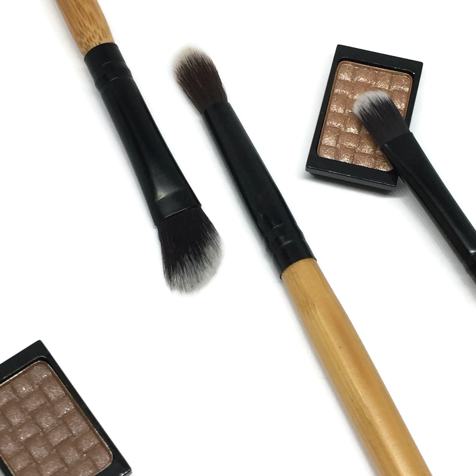 The Trilogy Eye Brush Set featuring three essential brushes for eyeshadow application and blending, showcasing a small flat brush, blending brush, and angled blending brush.