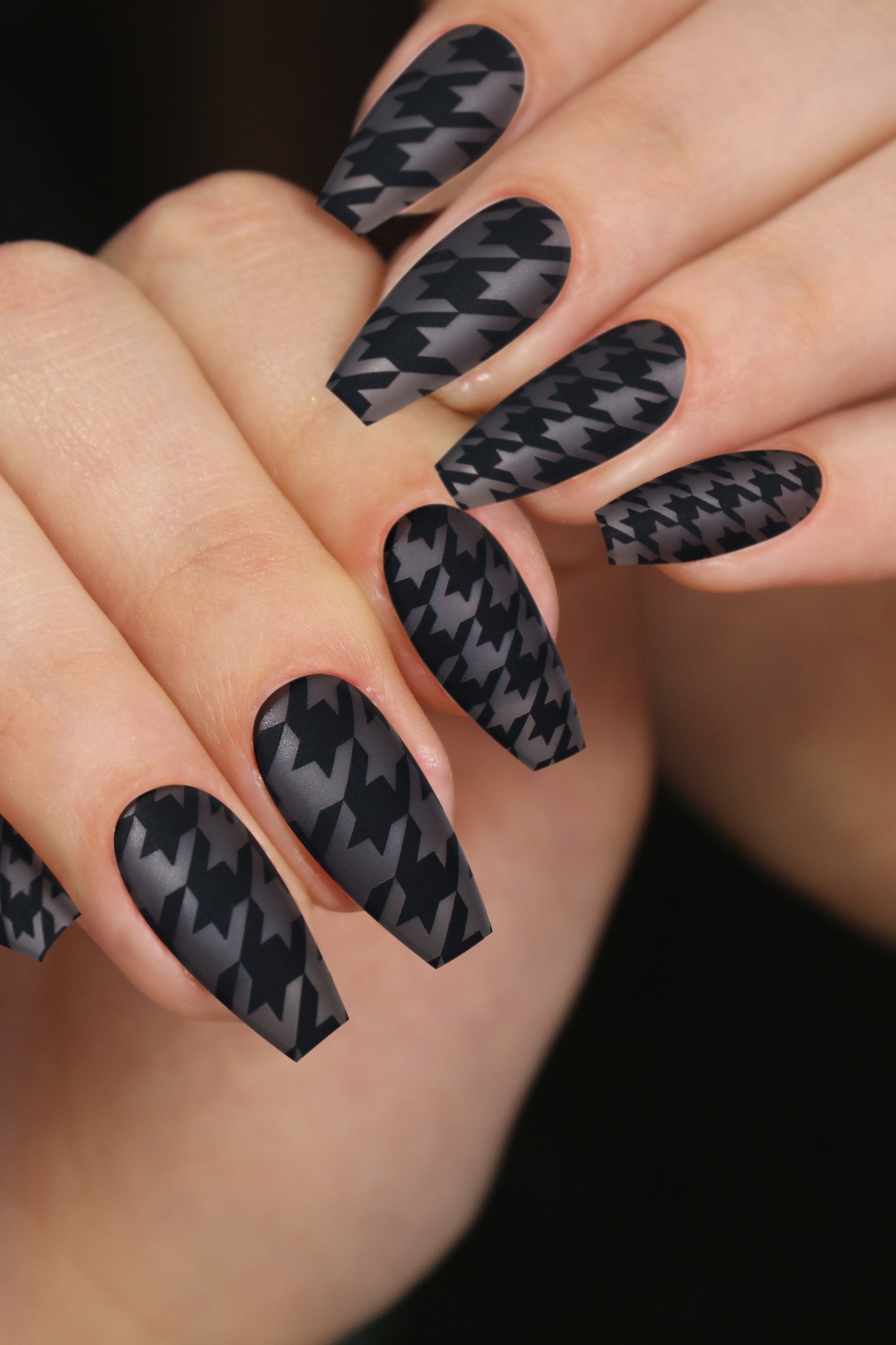 Chic Mood press-on nails featuring a grey base with a black houndstooth pattern, elegantly displayed with nail care accessories.